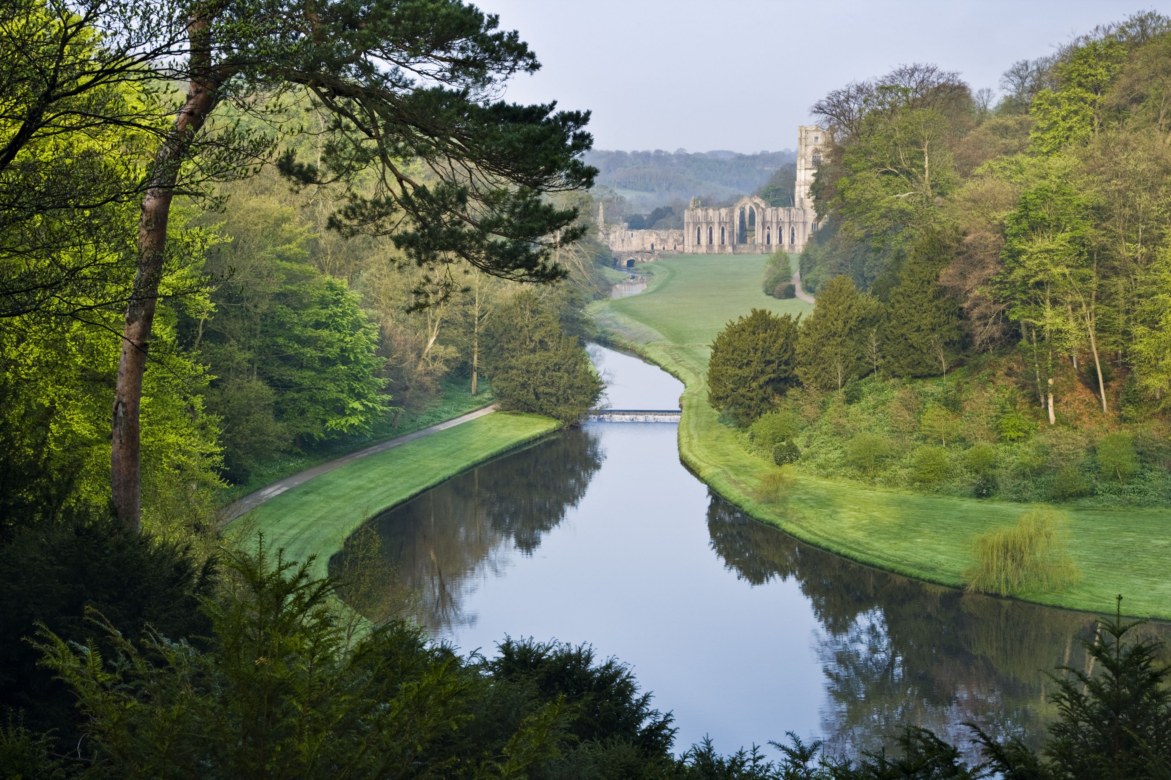 Looking over the Half Moon Pond and weir of Studley Royal Water Garden from the Surprise View towards Fountains Abbey, North Yorkshire